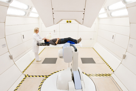 Gantry Radiation Therapy: The patient lies under a radiation delivery apparatus, which is set to precise specifications by a computer controlled robot. Photo: Universitätsklinikum Heidelberg