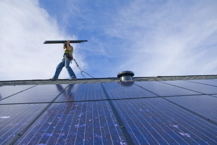 19 Feb 2009, Redmond, Washington State, USA --- Solar panels installed on rooftop of new home at the Trilogy development in Redmond, WA. Workers for Puget Sound Solar are Dave Lazerwitz (yellow hard hat) and Michiel Zuidweg (white hard hat). --- Image by © Kevin Horan/Aurora Photos/Corbis