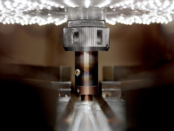 Zu sehen ist ein typischer Rührreibschweißkopf (Friction Stir Welding - FSW). Unten ist der Stift und die gefügte Naht auf den Metallplatten zu erkennen. Die Ansicht ist in Fügerichtung.