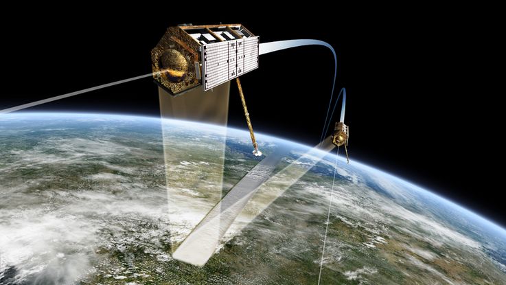 Die Satelliten TanDEM-X und TerraSAR-X fliegen in nördlicher Richtung über Deutschland entlang der Tag-Nacht-Grenze