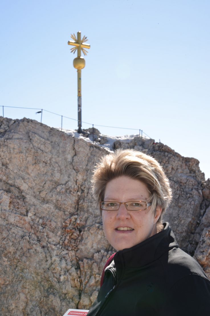 Kerstin Hürkamp vor dem Gipfelkreuz der Zugspitze.