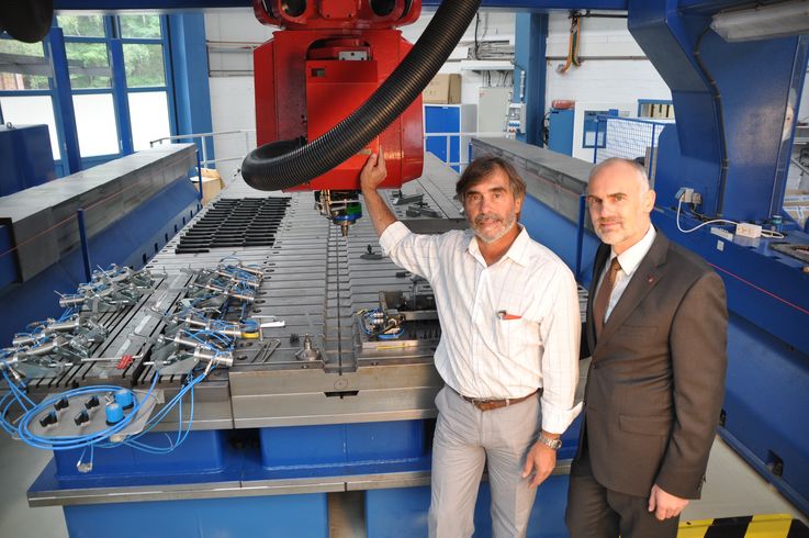 Jorge dos Santos (links) und Prof. Norbert Huber vor der sechseinhalb Meter langen Robotik-Portalanlage zum Schweißen von Flugzeugschalen in Geesthacht.